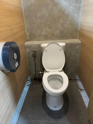 a small bathroom with a toilet in a stall at Glur Central Pratunam in Bangkok