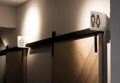 a shelf in a bathroom with toilet signs on it at Bed One Block Hostel in Bangkok
