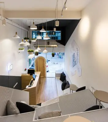 an office with a staircase and tables and chairs at Bed One Block Hostel in Bangkok