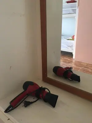 a red umbrella laying on the floor in front of a mirror at Indy house59 in Bangkok
