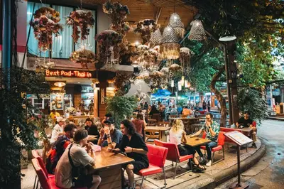 a group of people sitting at tables in a restaurant at Villa Cha-Cha Khaosan Rambuttri in Bangkok