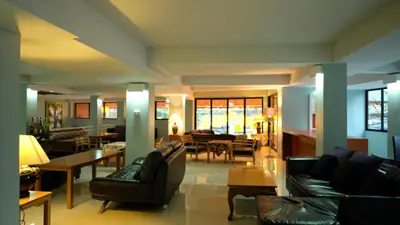 a living room with couches and chairs and tables at Villa Cha-Cha Khaosan Rambuttri in Bangkok