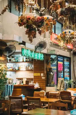 a restaurant with tables and chairs and chandeliers at Villa Cha-Cha Khaosan Rambuttri in Bangkok