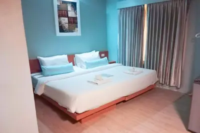 a bedroom with a large white bed with blue walls at Villa Cha-Cha Khaosan Rambuttri in Bangkok