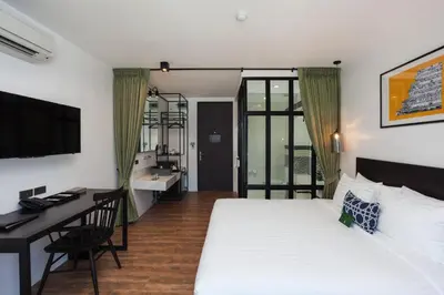 a hotel room with a bed and a desk and a computer at Oriental Heritage Hotel in Bangkok