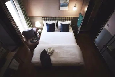 a bedroom with a large bed with blue pillows at Josh Hotel in Bangkok