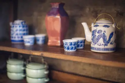 a shelf with blue and white cups and a vase at Vera Nidhra - Self check-in after 6pm in Bangkok
