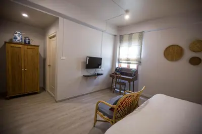 a room with a bed and a chair and a television at Vera Nidhra - Self check-in after 6pm in Bangkok