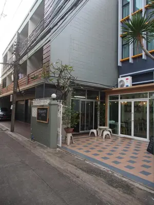 a building with a courtyard with benches in front of it at Sriyanar Place in Bangkok
