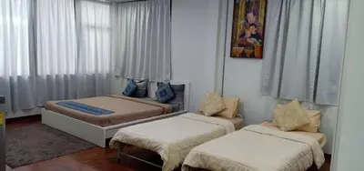 a small room with two beds and a couch at Sriyanar Place in Bangkok