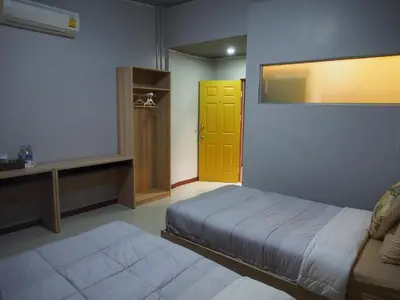 a bedroom with a bed and a yellow door at Sriyanar Place in Bangkok