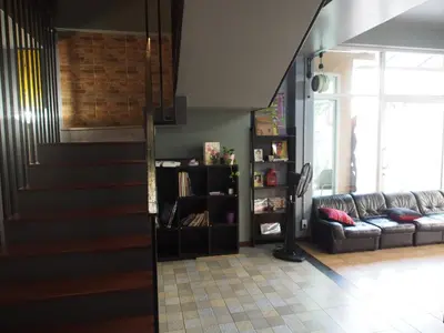 a living room with a staircase and a couch at Sriyanar Place in Bangkok