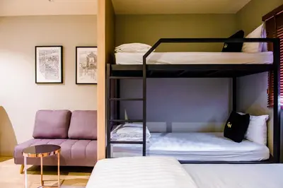 a room with two bunk beds and a couch at GN Luxury Hostel in Bangkok