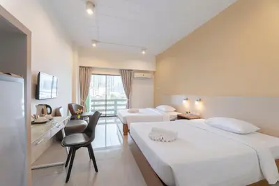 a bedroom with two beds and a desk and a chair at At 115 Hotel By Rompo in Bangkok