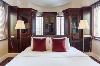 a bedroom with a large bed with red pillows at The Lek Aree in Bangkok