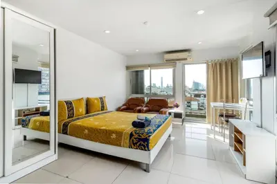 a bedroom with a bed and a living room at Right Place Sathorn in Bangkok