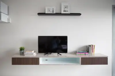 a flat screen tv sitting on top of a entertainment center at Q Space Residence in Bangkok