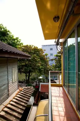 an outside balcony of a building with a staircase at Lamphu Tree House Boutique Hotel in Bangkok