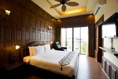 a hotel room with a bed and a large window at Lamphu Tree House Boutique Hotel in Bangkok