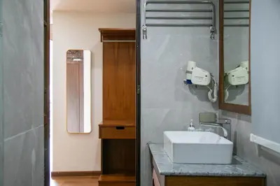 a bathroom with a white sink and a mirror at Lamphu Tree House Boutique Hotel in Bangkok