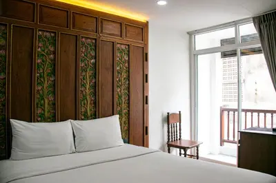 a bedroom with a white bed and a window at Lamphu Tree House Boutique Hotel in Bangkok