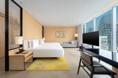 a hotel room with a bed and a tv at Park Hyatt Bangkok in Bangkok