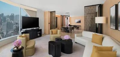 a living room with a couch and chairs and a tv at Park Hyatt Bangkok in Bangkok