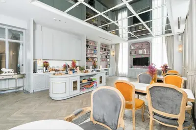 a room with a table and chairs and a kitchen at The Salil Hotel Sukhumvit 57 - Thonglor in Bangkok