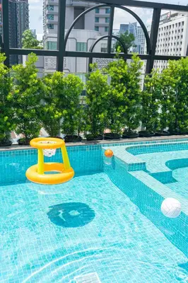 a swimming pool with a yellow toy in a city at The Salil Hotel Sukhumvit 57 - Thonglor in Bangkok