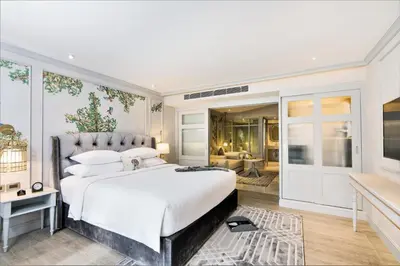 a bedroom with a large bed and a living room at The Salil Hotel Sukhumvit 57 - Thonglor in Bangkok