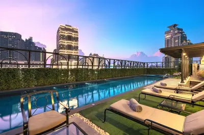 a pool with chaise lounges on the roof of a building at The Salil Hotel Sukhumvit 57 - Thonglor in Bangkok