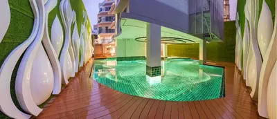 an indoor pool on a building with a green floor at Anajak Bangkok Hotel - SHA Plus in Bangkok