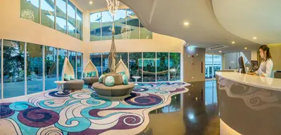 a woman is standing in a room with a lobby at Anajak Bangkok Hotel - SHA Plus in Bangkok
