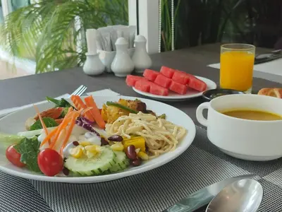 a table with a plate of food and a cup of coffee at Anajak Bangkok Hotel - SHA Plus in Bangkok