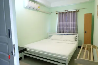 a small bed in a room with a window at Mahannop Hostel in Bangkok