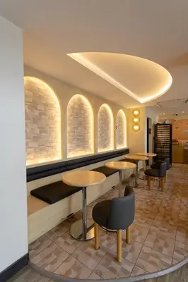 a restaurant with tables and chairs and windows at IR-ON Hotel in Bangkok