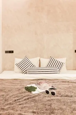 a bed with black and white pillows and a pair of scissors at Vann Bangkok Boutique House in Bangkok
