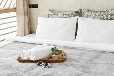 a bed with a tray of towels and scissors on it at Vann Bangkok Boutique House in Bangkok