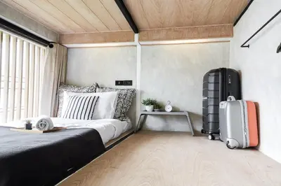 a bedroom with a bed and a suitcase at Vann Bangkok Boutique House in Bangkok