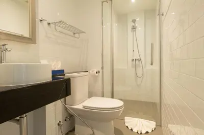 a bathroom with a toilet and a shower and a sink at Klub Hotel Bangkok in Bangkok