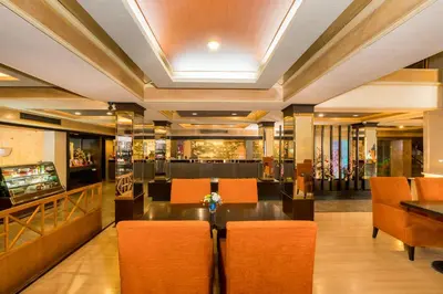 a restaurant with a table and chairs and a bar at Niran Grand Hotel in Bangkok