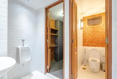 a bathroom with a toilet and a sink and a urinal at Siam Plug In Hostel in Bangkok