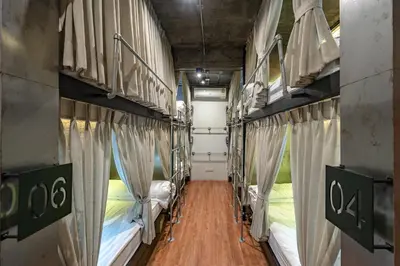 a room with two bunk beds with curtains at Siam Plug In Hostel in Bangkok