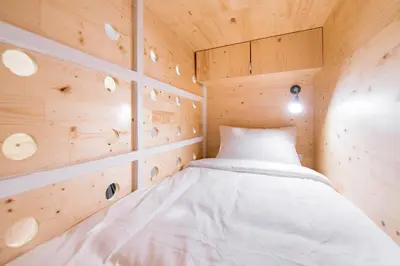 a bed in a room with wooden walls at Norn Yaowarat Hotel in Bangkok