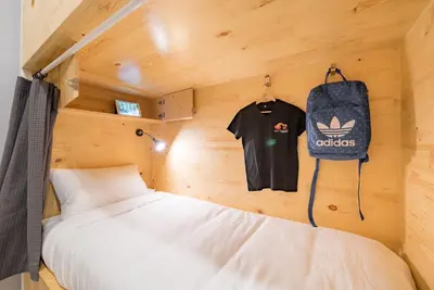 a bedroom with a bed and a bag on the wall at Norn Yaowarat Hotel in Bangkok
