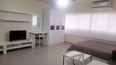 a bedroom with a bed and a desk and a television at Popular Condo C4 in Nonthaburi