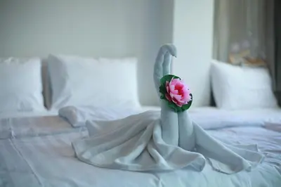 a white swan decoration on a bed with a flower at Darin Hostel in Bangkok