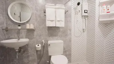 a bathroom with a toilet and a sink and a mirror at Neveu Premier Residence : Ratchada in Bangkok