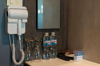 a room with a phone and bottles of water on a counter at BB House Phra Athit บีบี เฮ้าส์ พระอาทิตย์ in Bangkok