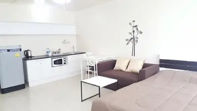 a living room with a couch and a kitchen at Popular Condo C6 in Nonthaburi